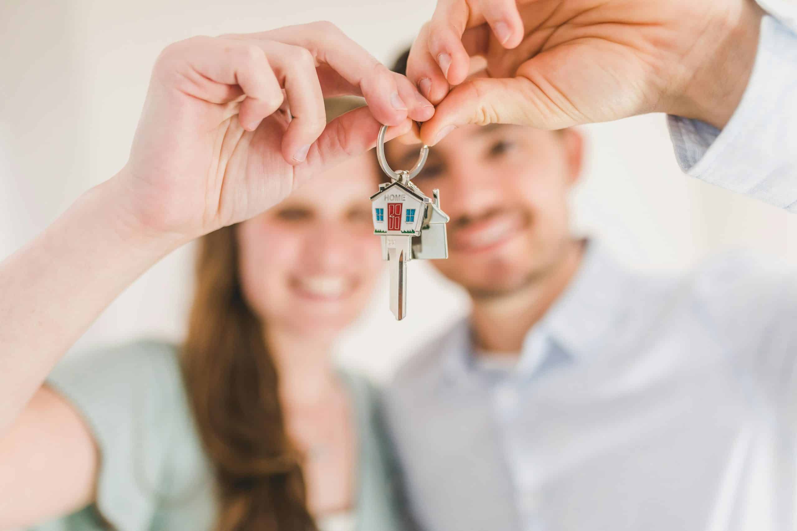 Mortgage Leads And Lists Young couple holding keys to their new home, symbolizing a fresh start and investment in real estate.